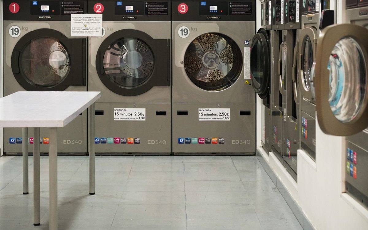 Row of industrial washing machines in a commercial laundry room